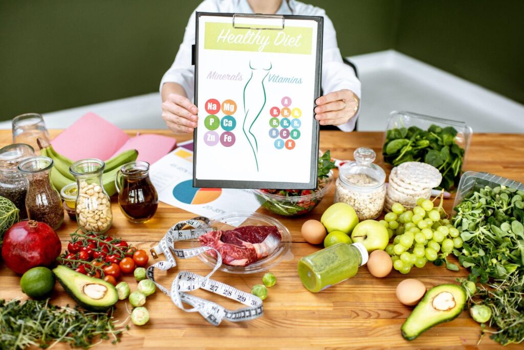 Nutritionist presenting a healthy diet chart surrounded by fresh fruits, vegetables, and supplements, supporting a science-based weight loss program in Wilmington, NC.